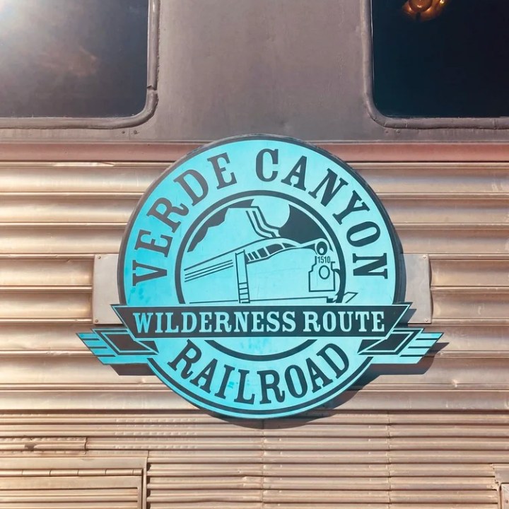 Logo of Verde Canyon Railroad on a metal train surface with windows.